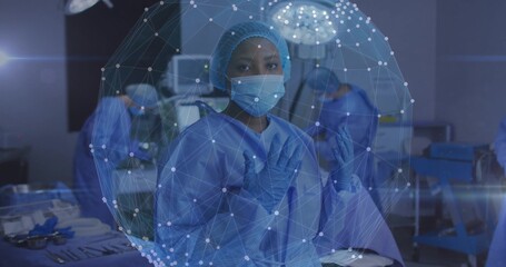 Preparing lead surgeon in blue gown adjusting gloves in OR with sterile tray, network sphere