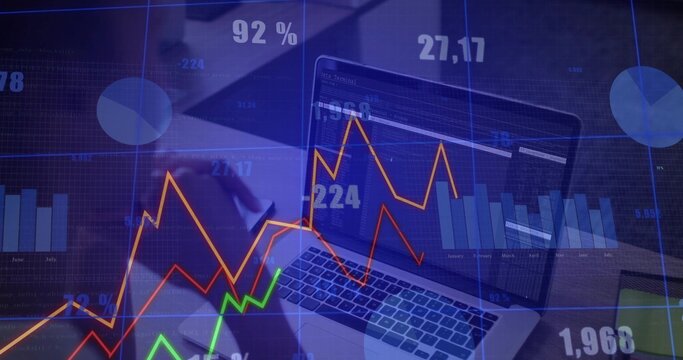 Analyzing analyst in dark blouse reviewing laptop at office desk, with charts phone overlays - Powered by Adobe