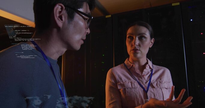 Discussing systems, IT staff gesturing in server room with pink shirt, blue lanyards, code overlay