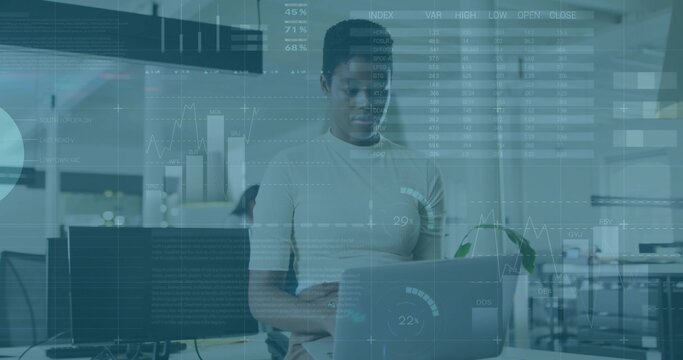 Standing worker wearing light top checking laptop and left monitor at office, HUD overlays