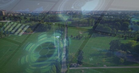 Fototapeta premium Stretching central tree-lined walkway through urban park, showing lamp posts, benches, pond and HUD