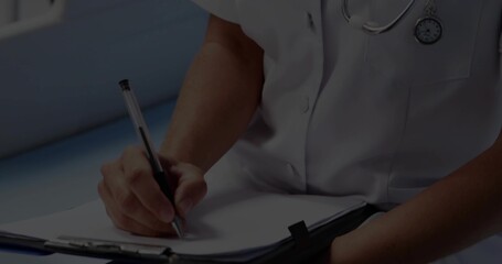 Writing mid-adult clinician filling patient form in clinic wearing white medical top and clipboard