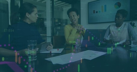 Presenting central woman wearing mustard sweater gesturing at meeting table, with laptop charts