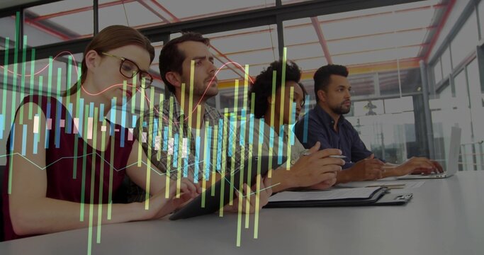 Reviewing charts, team discussing data in meeting room with laptop and tablet, in business attire