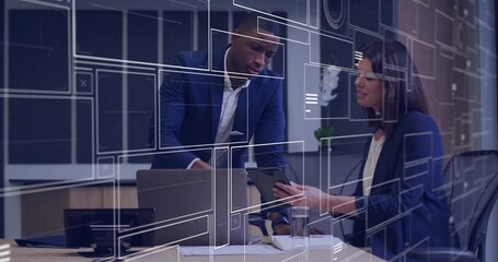Leaning two coworkers in suits pointing at laptop and reviewing tablet at office, HUD overlays