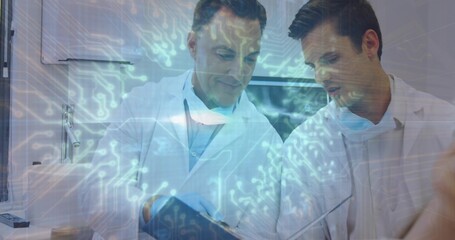 Reviewing two clinicians pointing at tablet in exam room in lab coats and masks, digital overlay
