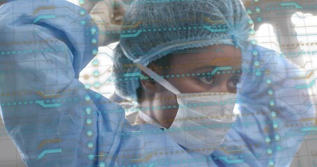 Adjusting nurse securing mask straps in OR, with bouffant cap, surgical gown, digital overlay
