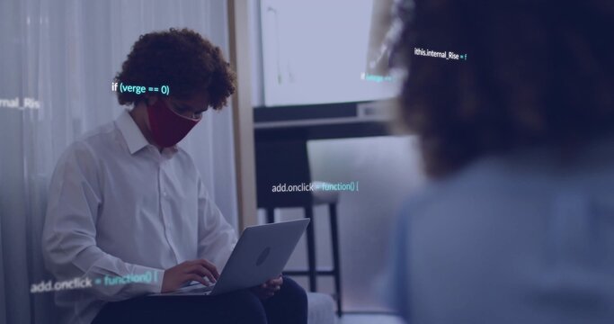Typing man wearing white shirt and red mask on sofa in office, laptop with code overlay