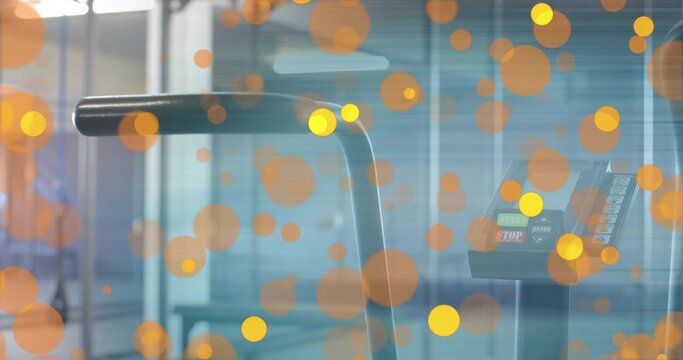 Fototapeta Displaying treadmill handrail and control console in fitness center, showing STOP button and bokeh