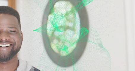 Smiling man wearing gray hoodie facing forward at home wall, with mirror, green mesh, copy space