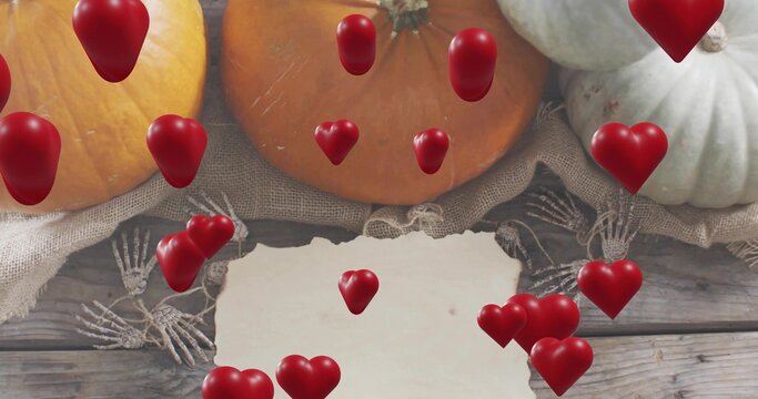 Fototapeta Displaying torn blank paper sitting on wood plank with burlap pumpkins, skeleton hands, red hearts
