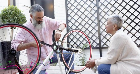 Man stabilizing bike and tightening crank after pulling part, woman handing cloth, DIY repair
