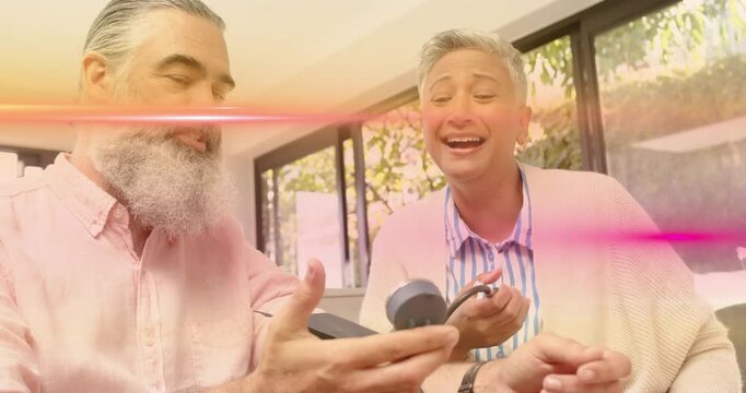 Man holding BP cuff while woman pressing monitor causing pink flare during health demo glass doors