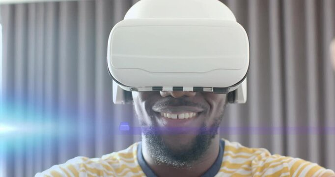 Man lowering VR headset, adjusting headset and exploring virtual elements around hands in tech demo