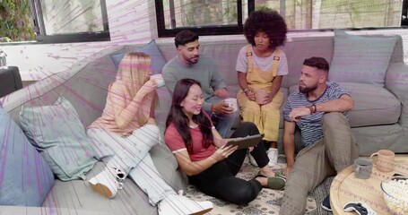 Woman on floor tapping tablet sharing tech demo with friends, animated icons rising, evoking smiles