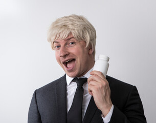Man holding white pill bottle. Man pills. Diet. Business concept. Work. Emotion face. Funny. Male. Photo
