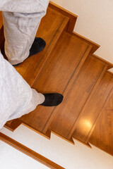 木製の階段を降りる人物