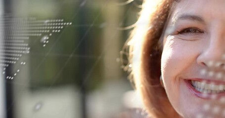 Senior woman shifting from neutral to laughing while transparent screen overlays revealing tech map