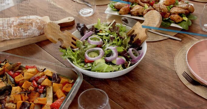 Camera starting slow pan revealing salad bowl, roasted veg, bread, chicken, showing table set