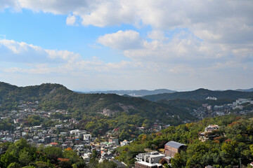 Obraz premium A village under a mountain in autumn under a rather cloudy blue sky