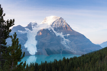 A serene view of a glacier-topped mountain reflected in a turquoise lake.
