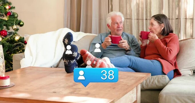 Senior couple with mugs on couch, social media bubble appearing profiles floating to 95 celebrating