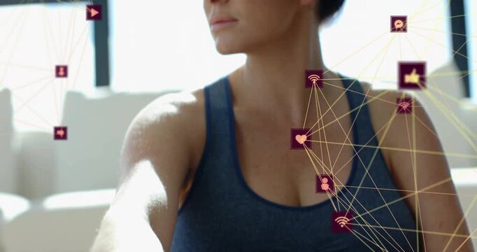 Camera pulling back woman sitting touching navel then turning head animated health icons on right