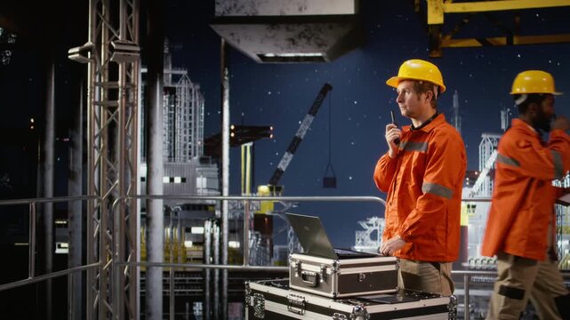 Offshore drilling rig engineer speaking through walkie talkie with colleagues, monitoring oil extraction systems for efficiency. Trying to minimize carbon footprint levels on platform. Camera A.