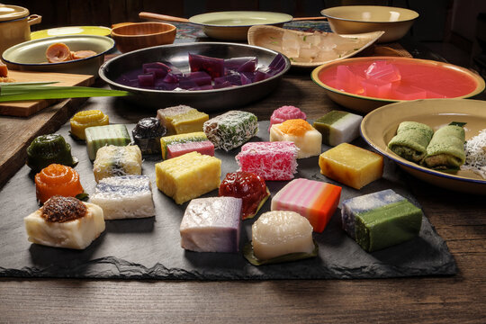 Traditional Malaysian desert Nonyah Kuih making preparing ingredients panadn leaf shredded coconut gula melaka  agar agar sagu spread over black slate messy rustic wood