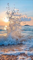 A dynamic splash of ocean water breaks on a pebble beach during a vibrant sunset. The golden light of the setting sun illuminates the water droplets and the sky