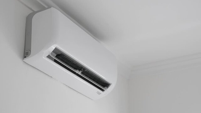 Flat air conditioner split system on white wall in room. closeup