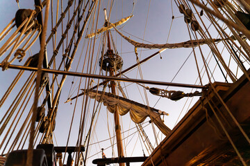 Sailing Ship Rigging and Pulley System Silhouette Against Blue Sky