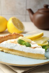 Slice of tasty lemon meringue tart served on table, closeup