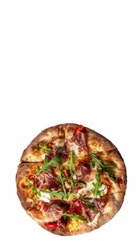 Prosciutto pizza with strachatella cheese, tomatoes and arugula leaves, top view, closeup object. Rotating on white background. Vertical footage