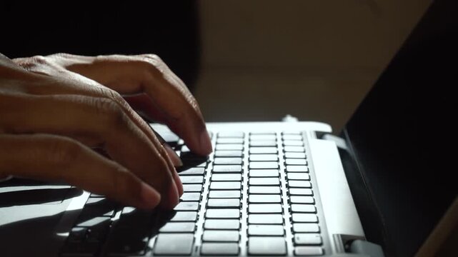 Fingers typing on a laptop keyboard. Focus selected.