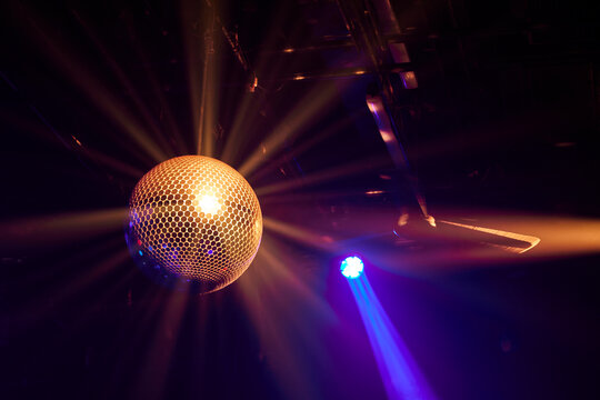The mirror ball glistening in the club's orange lights.