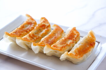 焼き餃子 - 外がパリパリ、中がジューシー、焦げ目がおいしそうな焼きギョウザ
