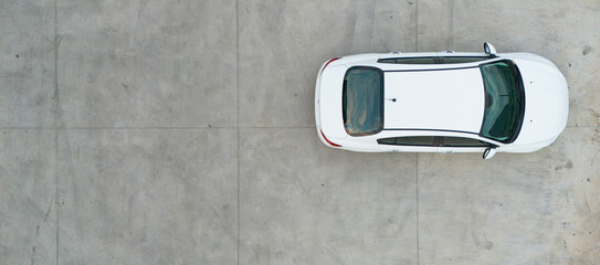 Close up top down aerial shot of a white car on concrete pavement highlighting the vehicle shape and design from above © Buğra Kaan Ersoy