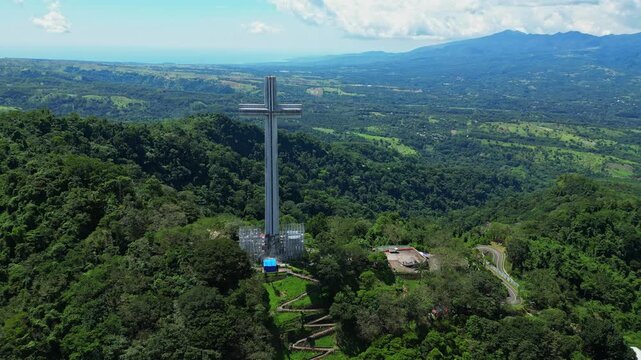 Elevated pull‑out aerial showcasing the towering Mt. Samat National Shrine as it recedes into view, framed by lush forested hills and sweeping valleys in Pilar, Bataan, Philippines.