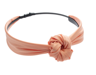Peach-colored fabric headband with a large knotted design, resting on a black base