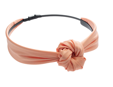 Peach-colored fabric headband with a large knotted design, resting on a black base