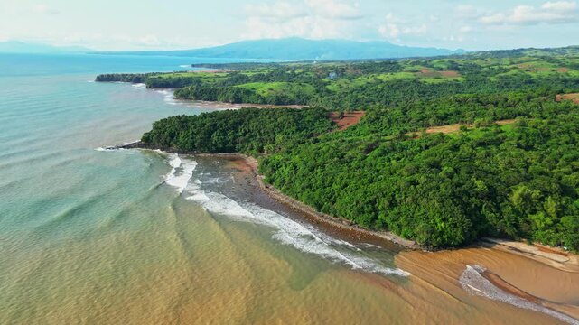 Elevated aerial capturing rolling hills covered in greenery above the coastline, with scenic views of the shoreline and tropical landscape near Quinawan Beach in Mariveles, Bataan, Philippines.
