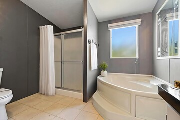 This is a bathroom that includes a tub, a toilet, a shower, and a window