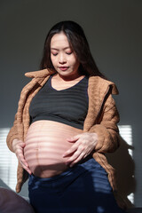 Tender maternal woman makes heart gesture on her belly. Important health consultation for new life and pregnancy