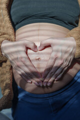 Pregnant Woman Making Heart Shape on Stomach: Prenatal Care, Pregnancy Wellness, and Maternity Health