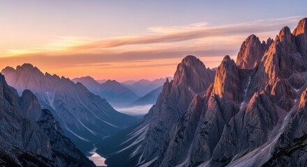 Majestic mountain landscape at sunrise, dramatic sky, misty valley below