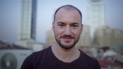 Smiling man with urban background in soft light