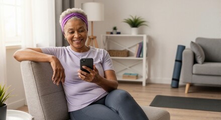 Combining fitness and technology: An older African American woman uses her smartphone after a workout.
