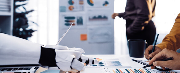 A dynamic meeting scene showcasing collaboration between humans and robots. The image highlights detailed charts and data-driven discussions in a modern office environment.Noogenesis