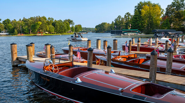 NISSWA, MN - 12 SEP 2024: Classic vintage wooden motorboats floating on the water, tied by rope to the dock on a beautiful Minnesota lake.